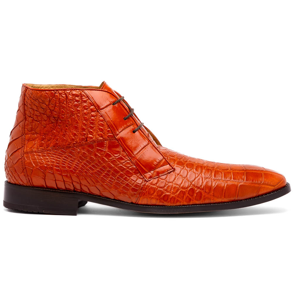 The Pietro Honey boots by Marco Di Milano are orange-brown genuine alligator, hand-painted with crocodile texture—displayed upright and sideway to show the sole—ideal for luxury footwear enthusiasts.