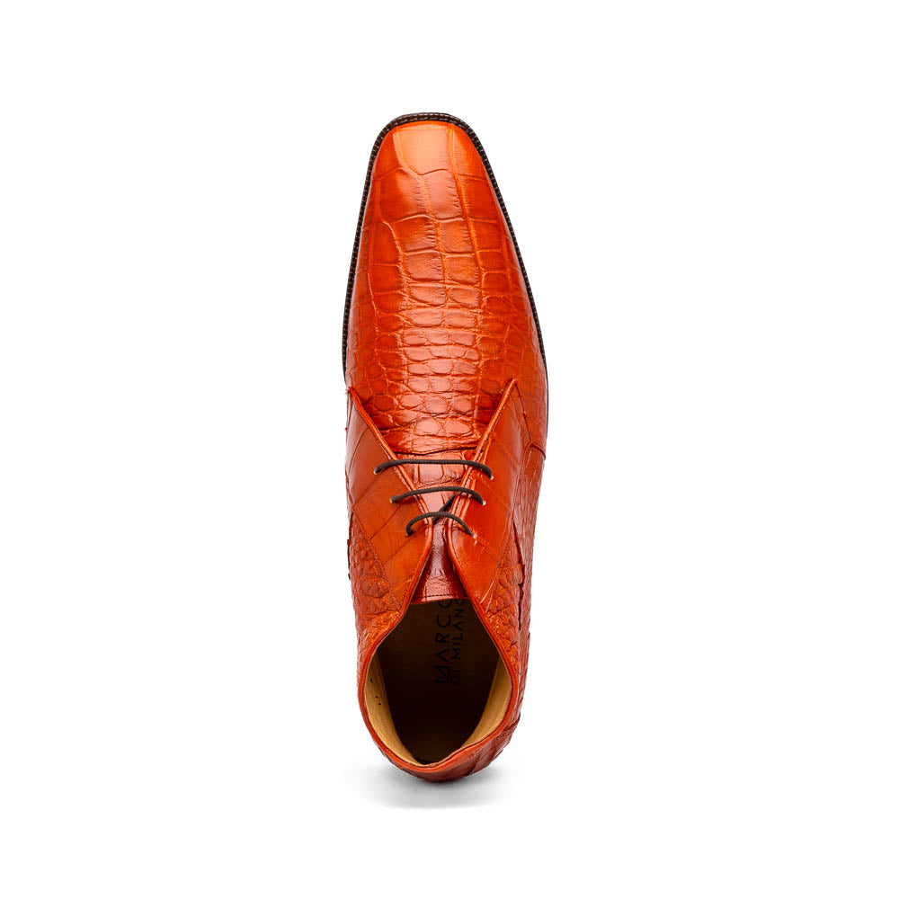 The Pietro Honey boots by Marco Di Milano are orange-brown genuine alligator, hand-painted with crocodile texture—displayed upright and sideway to show the sole—ideal for luxury footwear enthusiasts.
