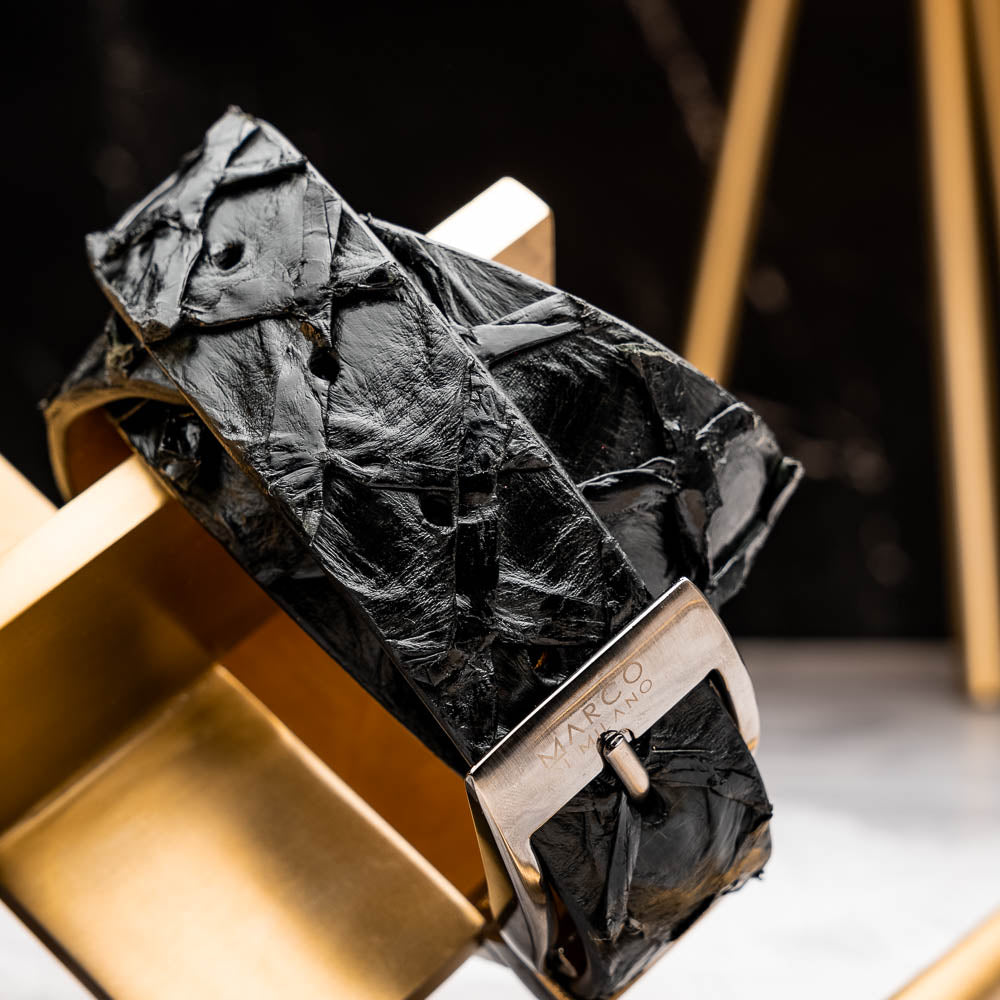 The Olivieri Belt Black by Marco Di Milano is a textured genuine pirarucu belt with a silver buckle, featuring the brand's logo—a refined accessory that pairs seamlessly with Marco Di Milano luxury footwear.