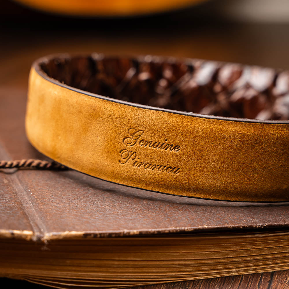 The Olivieri Belt Brown by Marco Di Milano is a genuine pirarucu leather belt with a textured finish, silver buckle, and "MD" initials—ideal for pairing with luxury footwear.