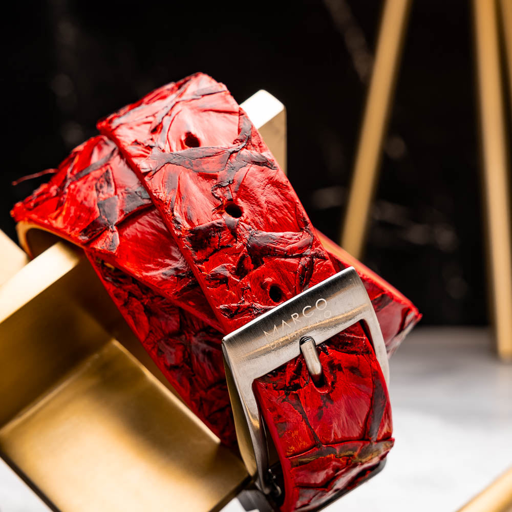 The Olivieri Belt Red by Marco Di Milano features textured genuine pirarucu leather and a metallic buckle with engraved branding, coiled on a white background—a signature accessory from this renowned luxury brand.