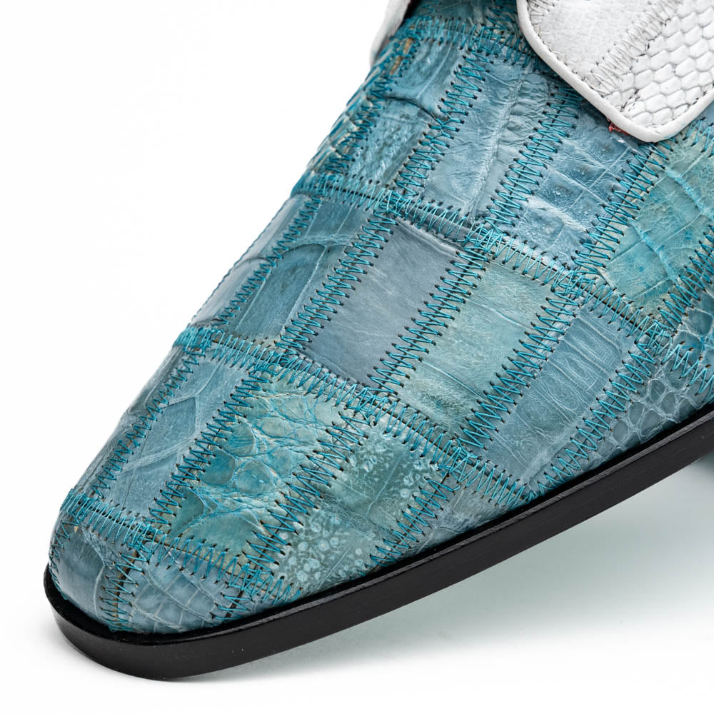 The "Pissa Aqua/White" by Marco Di Milano is a men's dress shoe with a white textured upper, teal blue patterned lower, hand-painted finishes, white laces, and a black sole—showcasing luxury style and craftsmanship.
