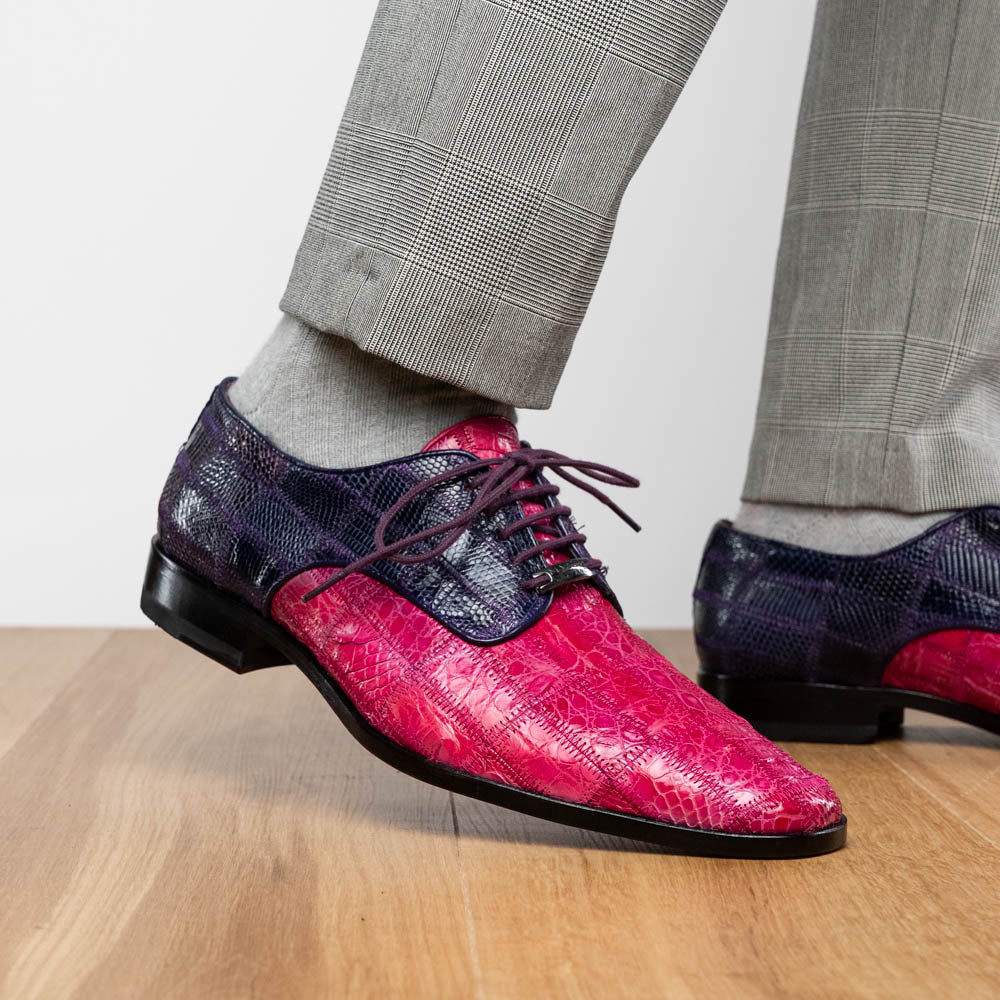 The Pissa Pink/Purple by Marco Di Milano are men's luxury dress shoes crafted from genuine exotics, featuring hand-painted pink and purple crocodile and lizard patterns—one shoe upright, the other on its side to display the sole.