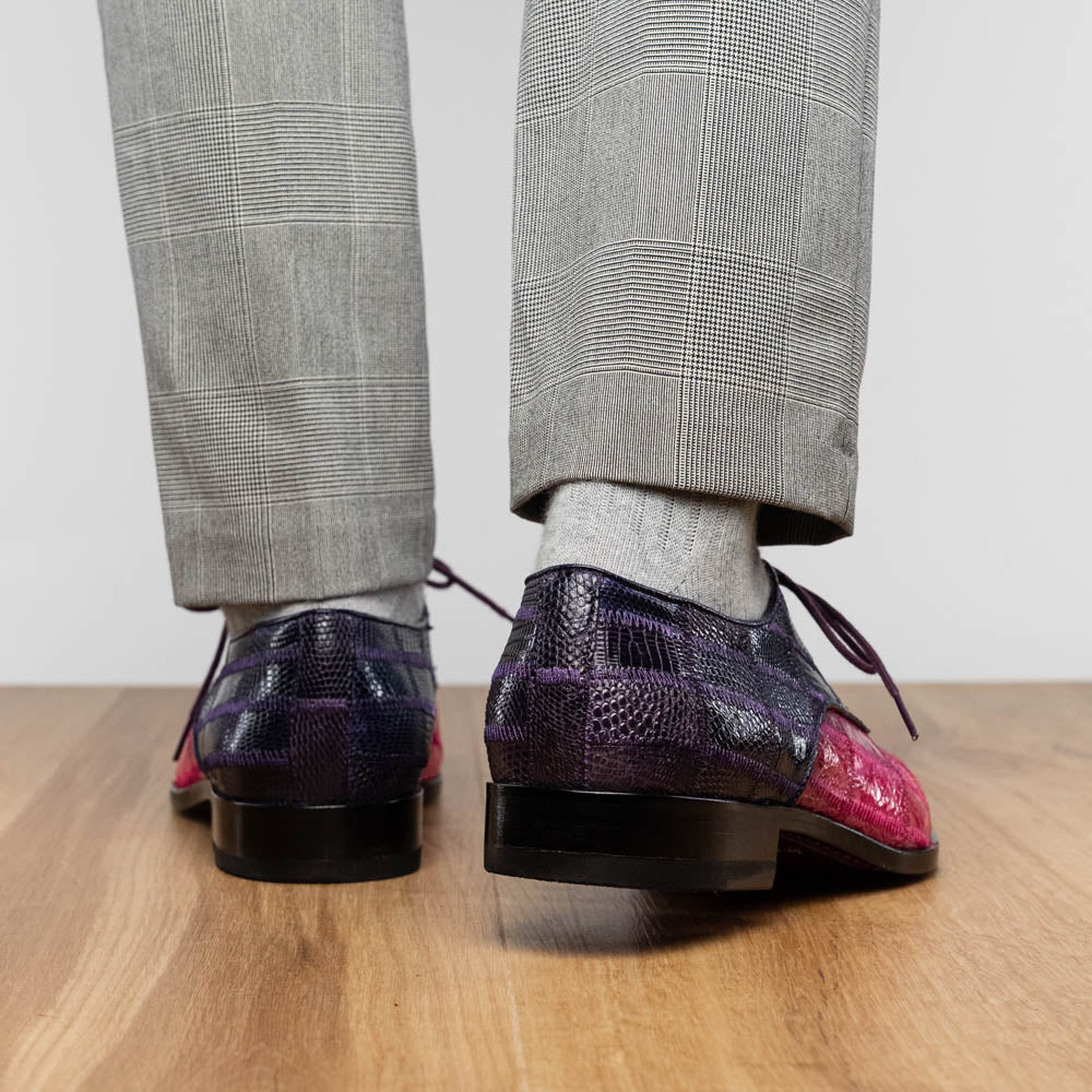 The Pissa Pink/Purple by Marco Di Milano are men's luxury dress shoes crafted from genuine exotics, featuring hand-painted pink and purple crocodile and lizard patterns—one shoe upright, the other on its side to display the sole.