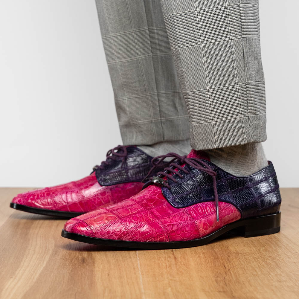 The Pissa Pink/Purple by Marco Di Milano are men's luxury dress shoes crafted from genuine exotics, featuring hand-painted pink and purple crocodile and lizard patterns—one shoe upright, the other on its side to display the sole.