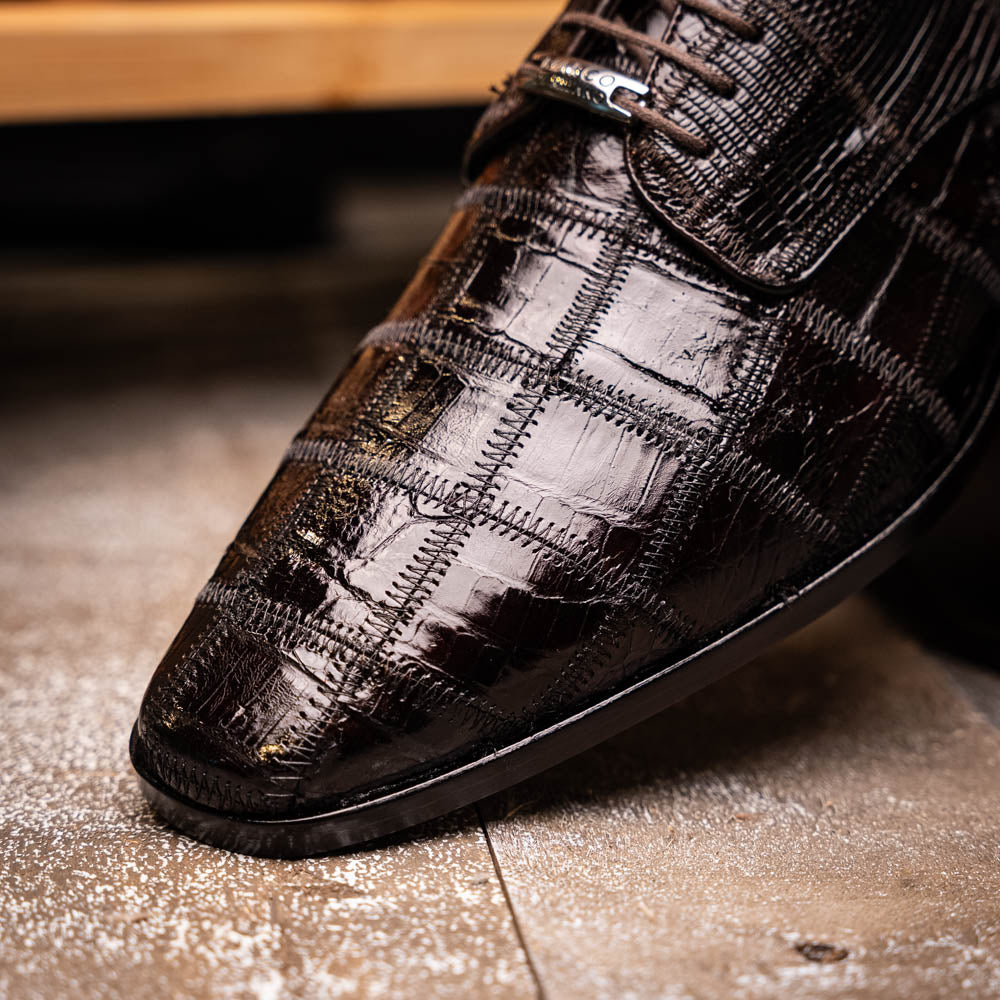 A pair of Marco Di Milano Pissa Brown textured leather dress shoes, with one shoe upright and the other on its side to showcase the sole.