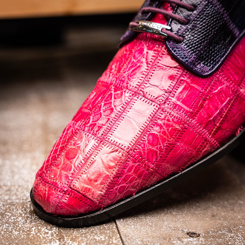 The Pissa Pink/Purple by Marco Di Milano are men's luxury dress shoes crafted from genuine exotics, featuring hand-painted pink and purple crocodile and lizard patterns—one shoe upright, the other on its side to display the sole.