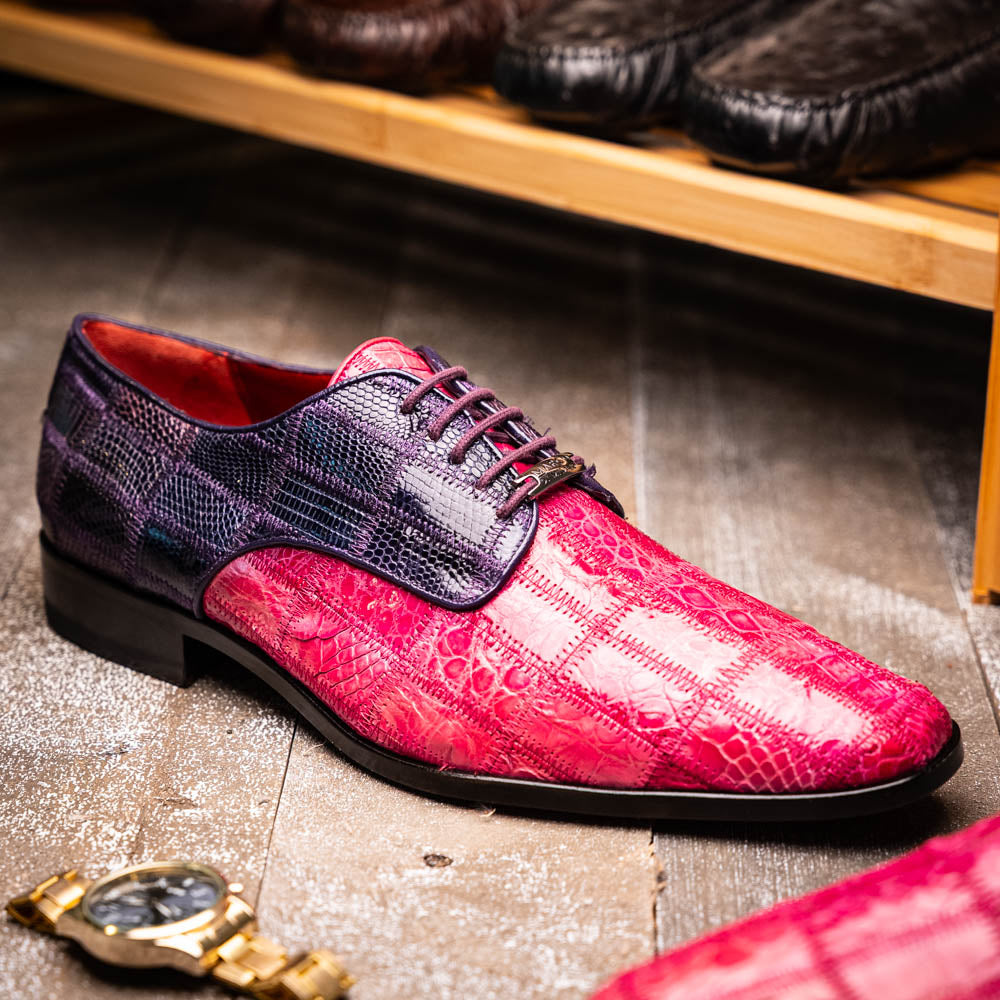 The Pissa Pink/Purple by Marco Di Milano are men's luxury dress shoes crafted from genuine exotics, featuring hand-painted pink and purple crocodile and lizard patterns—one shoe upright, the other on its side to display the sole.