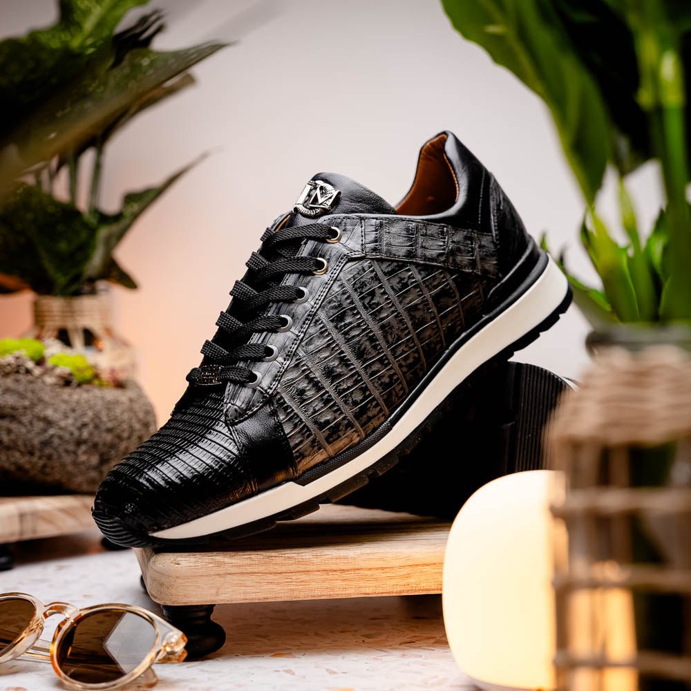 The Marco Di Milano Portici Gray / Black sneaker features black textured leather, black laces, and a white-trimmed rubber sole—one shoe upright and the other on its side—offering luxury footwear with a refined finish.