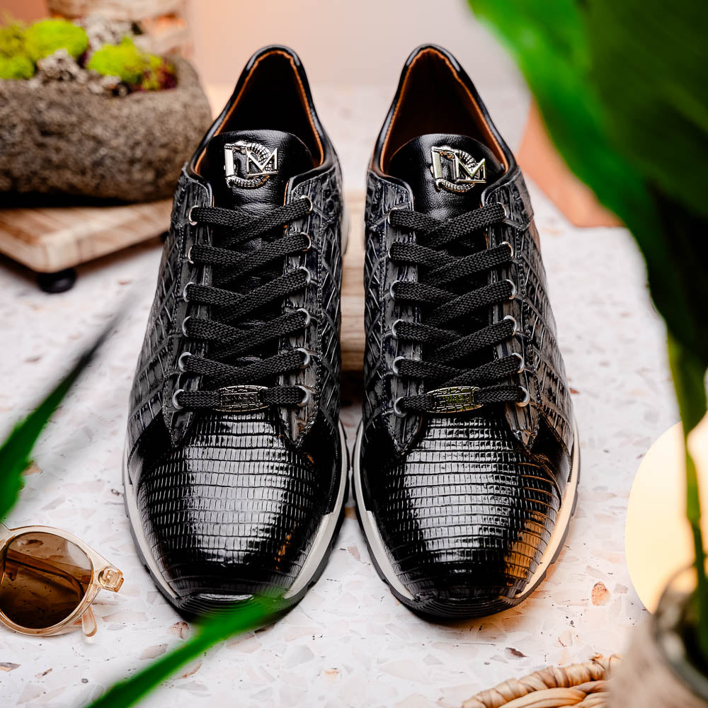 The Marco Di Milano Portici Gray / Black sneaker features black textured leather, black laces, and a white-trimmed rubber sole—one shoe upright and the other on its side—offering luxury footwear with a refined finish.