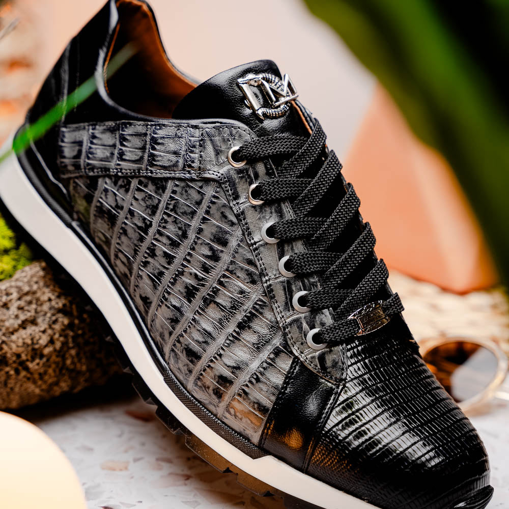 The Marco Di Milano Portici Gray / Black sneaker features black textured leather, black laces, and a white-trimmed rubber sole—one shoe upright and the other on its side—offering luxury footwear with a refined finish.