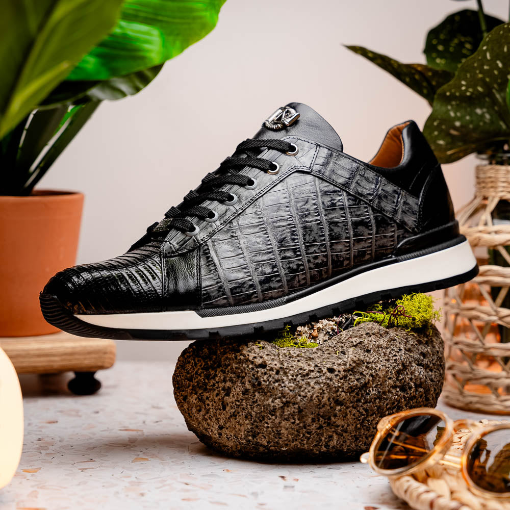 The Marco Di Milano Portici Gray / Black sneaker features black textured leather, black laces, and a white-trimmed rubber sole—one shoe upright and the other on its side—offering luxury footwear with a refined finish.