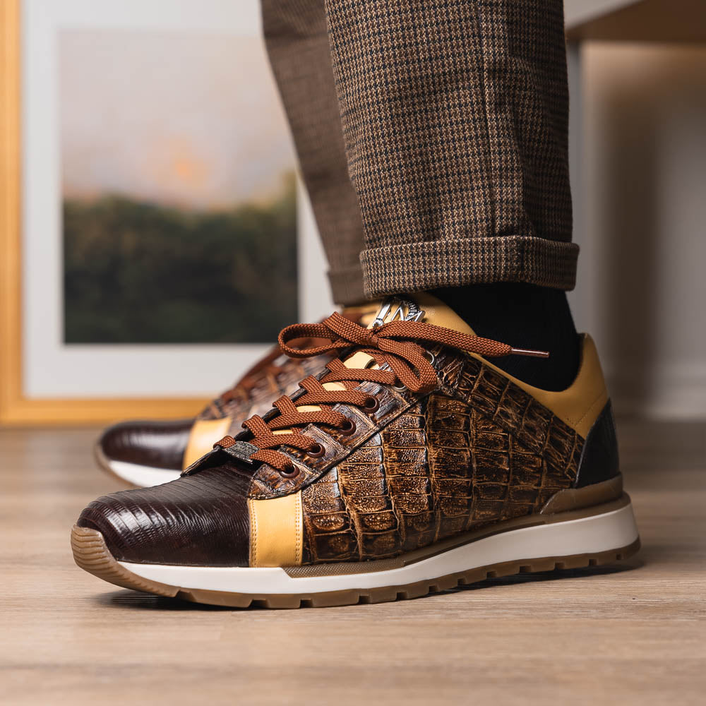 The Portici Orix / Brown by Marco Di Milano features a brown and tan faux crocodile texture, brown laces, white midsole, and a tan-brown rubber sole, delivering luxury style on a white background.