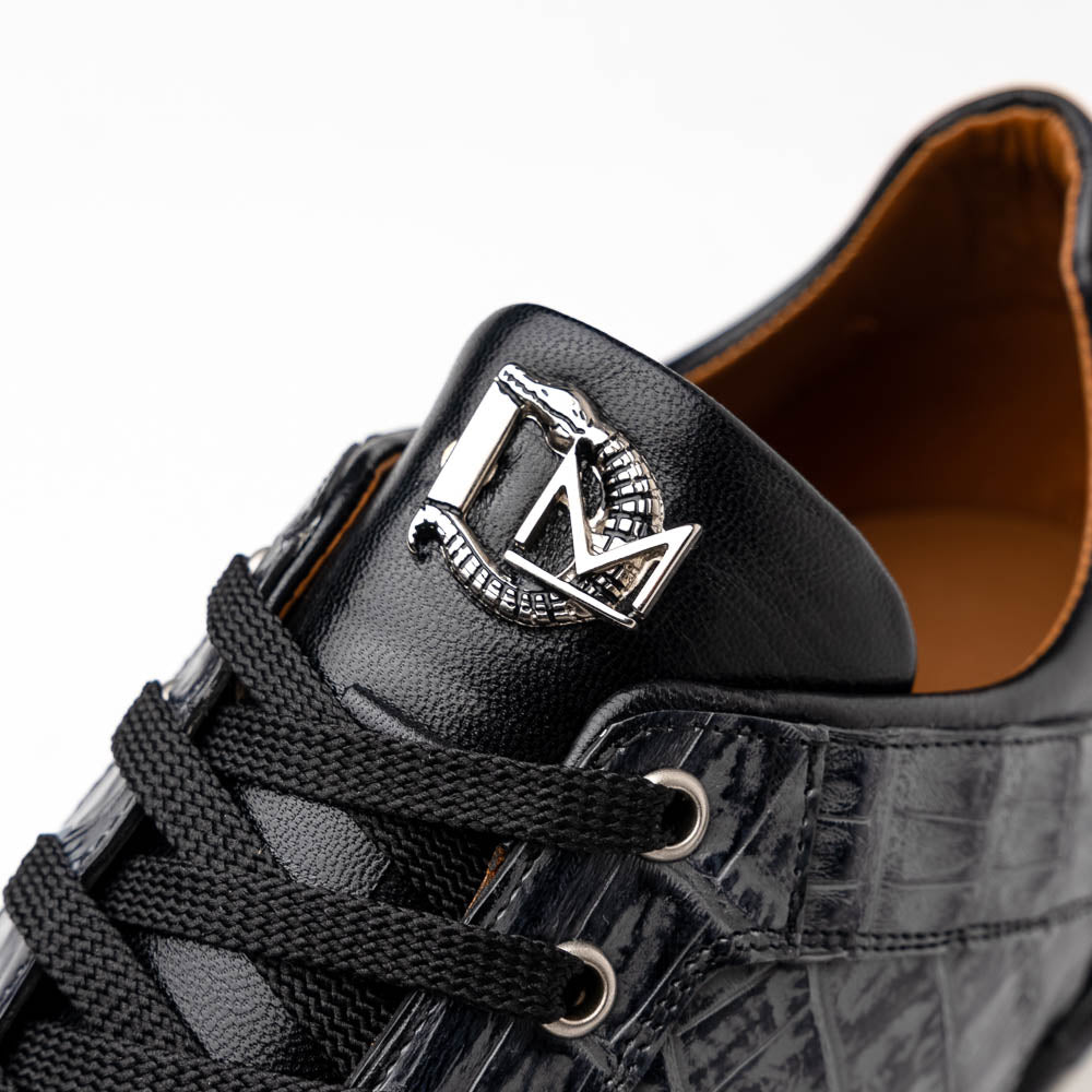 The Marco Di Milano Portici Gray / Black sneaker features black textured leather, black laces, and a white-trimmed rubber sole—one shoe upright and the other on its side—offering luxury footwear with a refined finish.