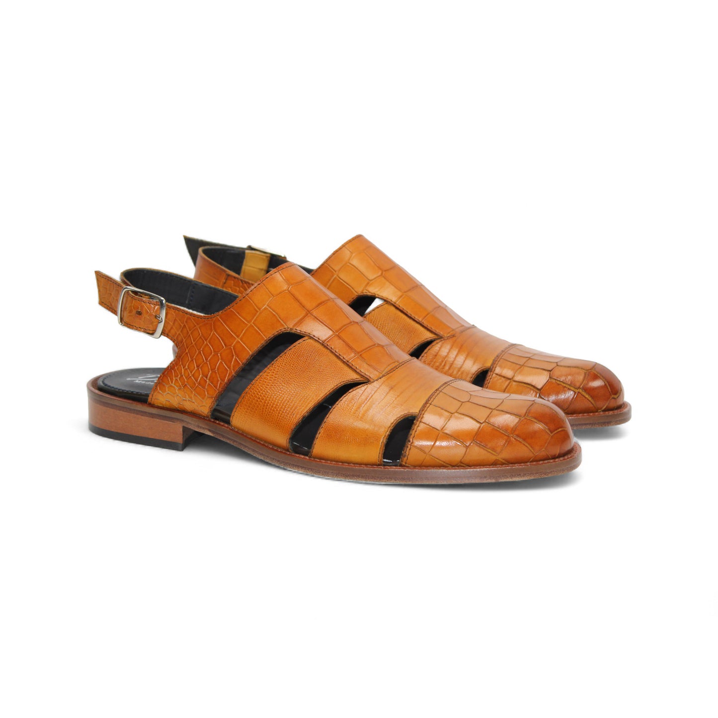 The Duca Di Matiste Positano (Cognac) is a brown croco embossed leather sandal with closed toe, cut-out sides, slingback strap with buckle, a textured pattern, and flat sole. Expertly crafted in Italy by Duca Di Matiste.