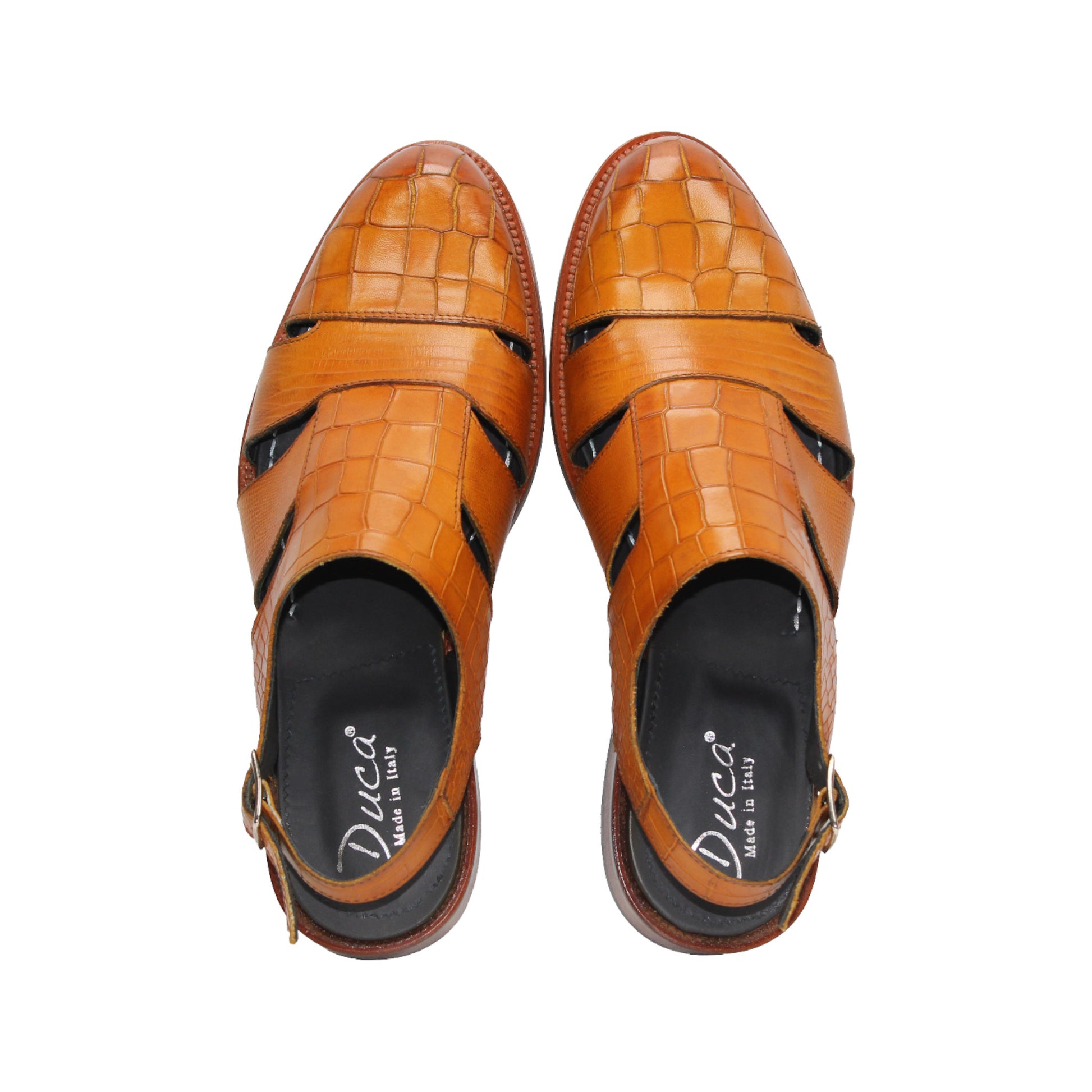 The Duca Di Matiste Positano (Cognac) is a brown croco embossed leather sandal with closed toe, cut-out sides, slingback strap with buckle, a textured pattern, and flat sole. Expertly crafted in Italy by Duca Di Matiste.
