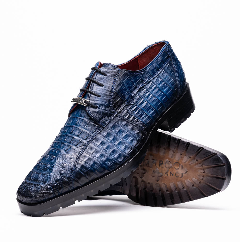 The Marco Di Milano Ragusa Stained Navy is a pair of luxury men's dress shoes in blue crocodile-patterned leather—one upright, one angled to display the sole—handcrafted for sophistication and timeless style.