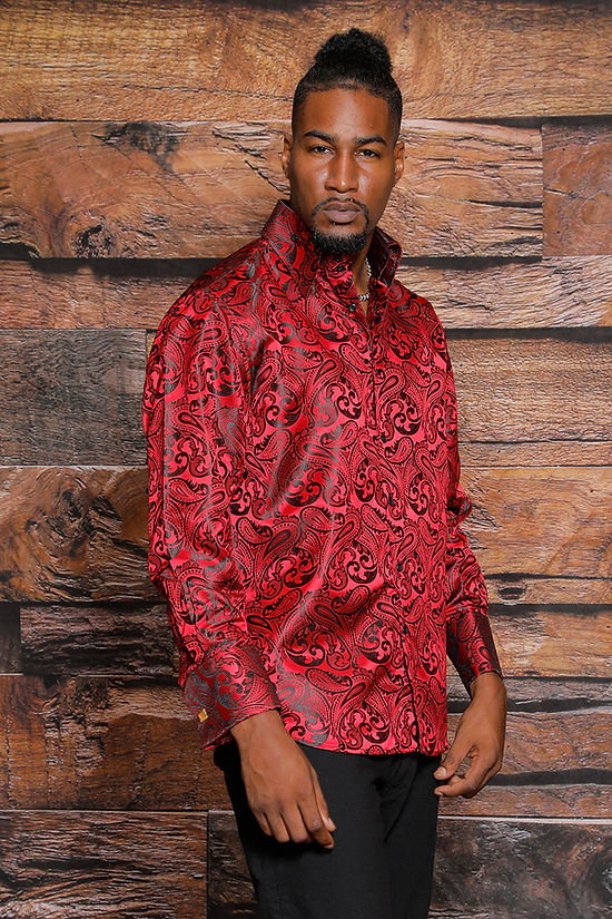 A man stands before a wooden textured wall wearing the Manzini MANZINI MZT-100 Paisley Long Sleeve Satin Red Black Shirt w/ Links, looking directly at the camera with a neutral expression.
