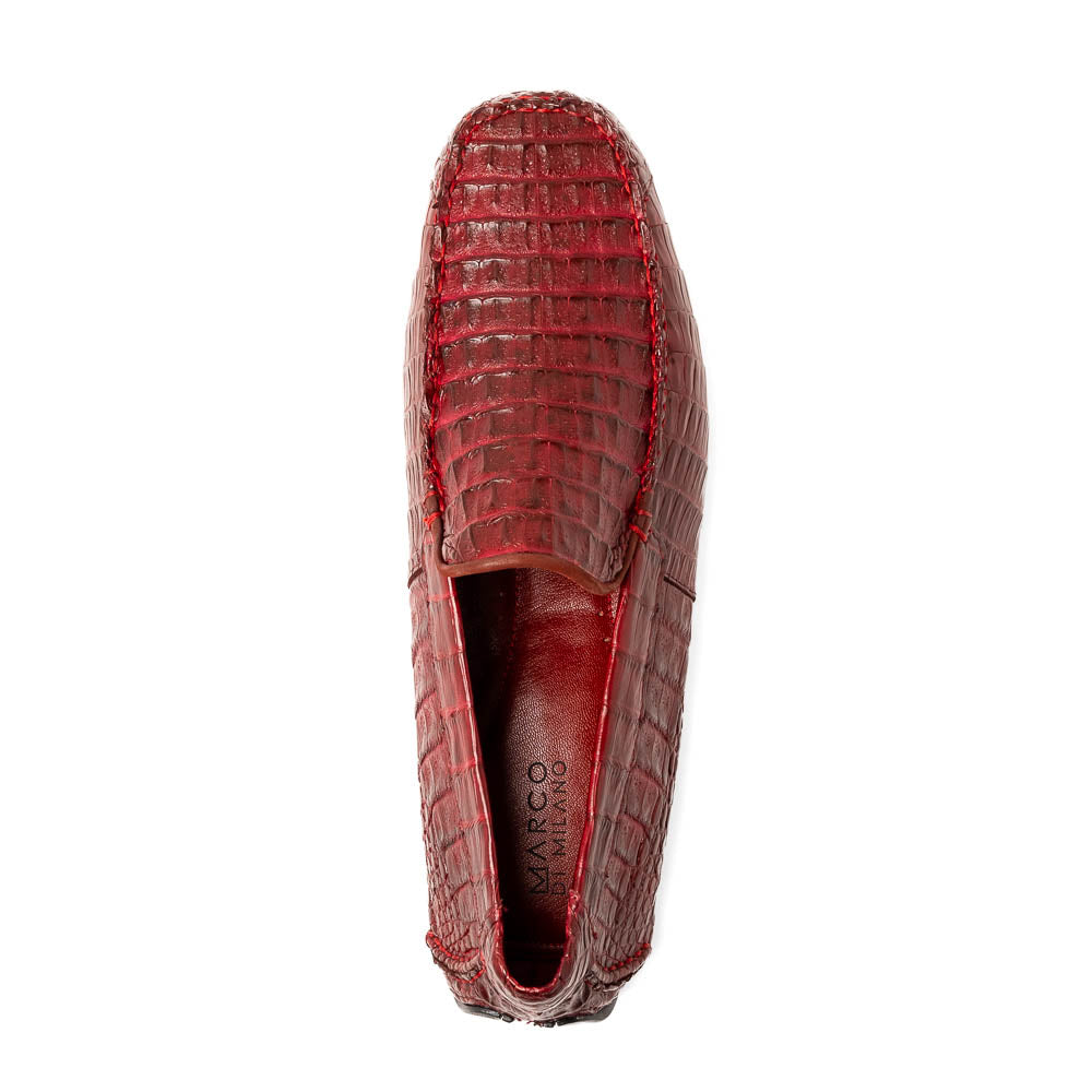 The Marco Di Milano Remo Wine features red crocodile-pattern leather driving shoes: one upright, one on its side showing a black rubber sole with red highlights—ideal for luxury men's footwear enthusiasts.