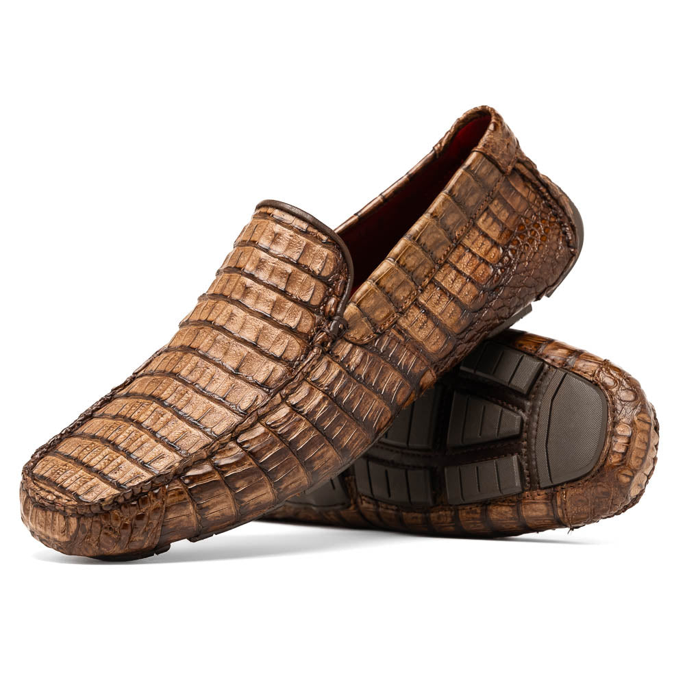 The Remo Washed Brown by Marco Di Milano features luxurious men's loafers with a crocodile texture. One shoe stands upright while the other lies on its side, revealing the detailed sole.