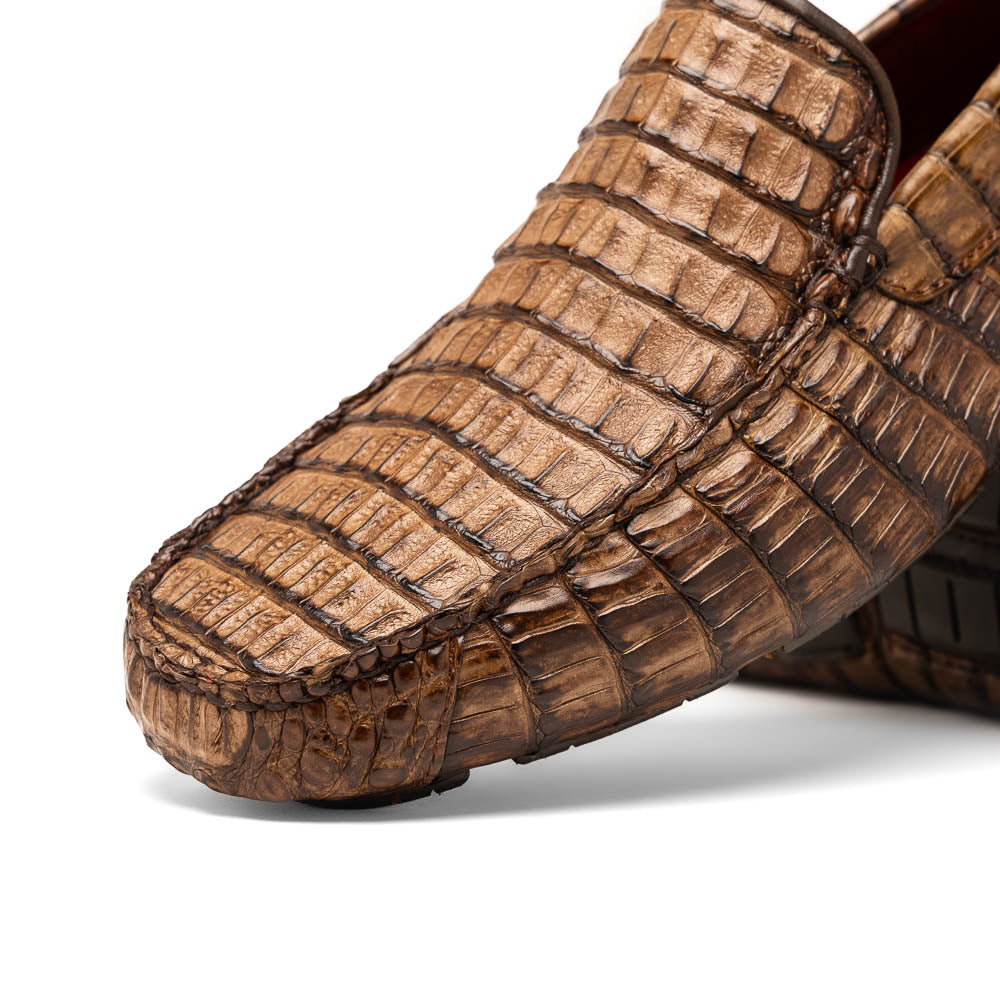 The Remo Washed Brown by Marco Di Milano features luxurious men's loafers with a crocodile texture. One shoe stands upright while the other lies on its side, revealing the detailed sole.