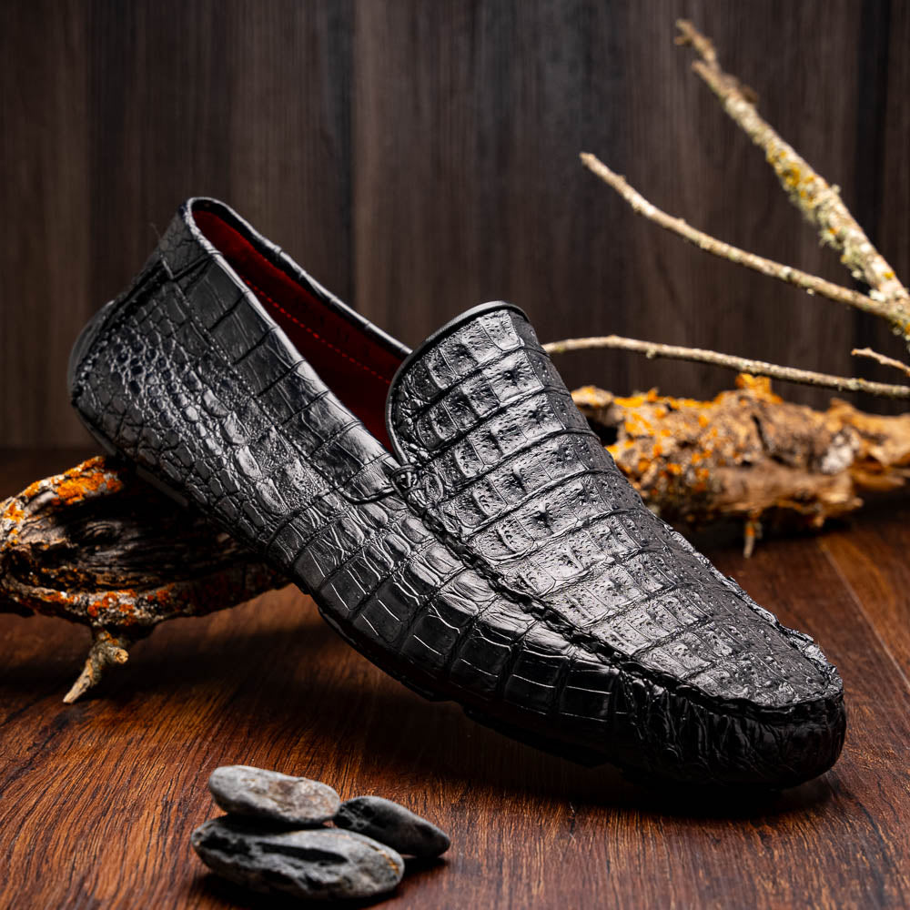 The Remo Black by Marco Di Milano: a pair of black textured driving loafers with a crocodile pattern—one upright, one showing the sole—making a bold statement in luxury men's footwear.