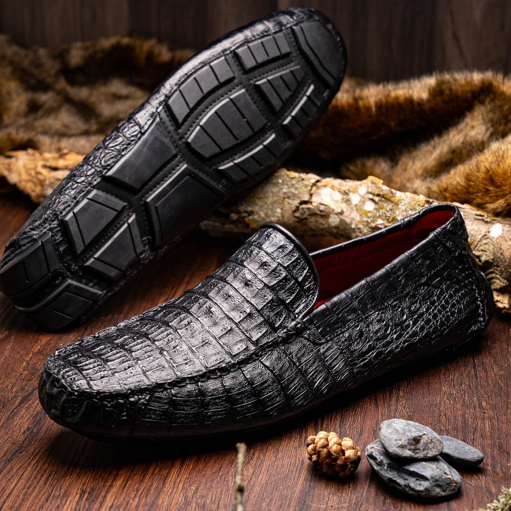 The Remo Black by Marco Di Milano: a pair of black textured driving loafers with a crocodile pattern—one upright, one showing the sole—making a bold statement in luxury men's footwear.