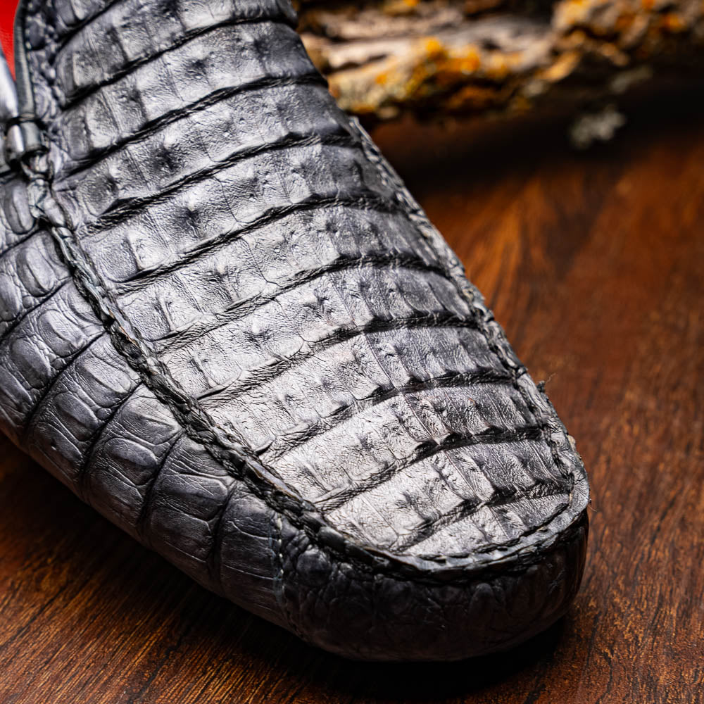 The Remo Gray driving loafers by Marco Di Milano feature a textured gray upper and rubber sole, with one shoe upright and the other leaning—ideal for genuine exotic footwear enthusiasts.