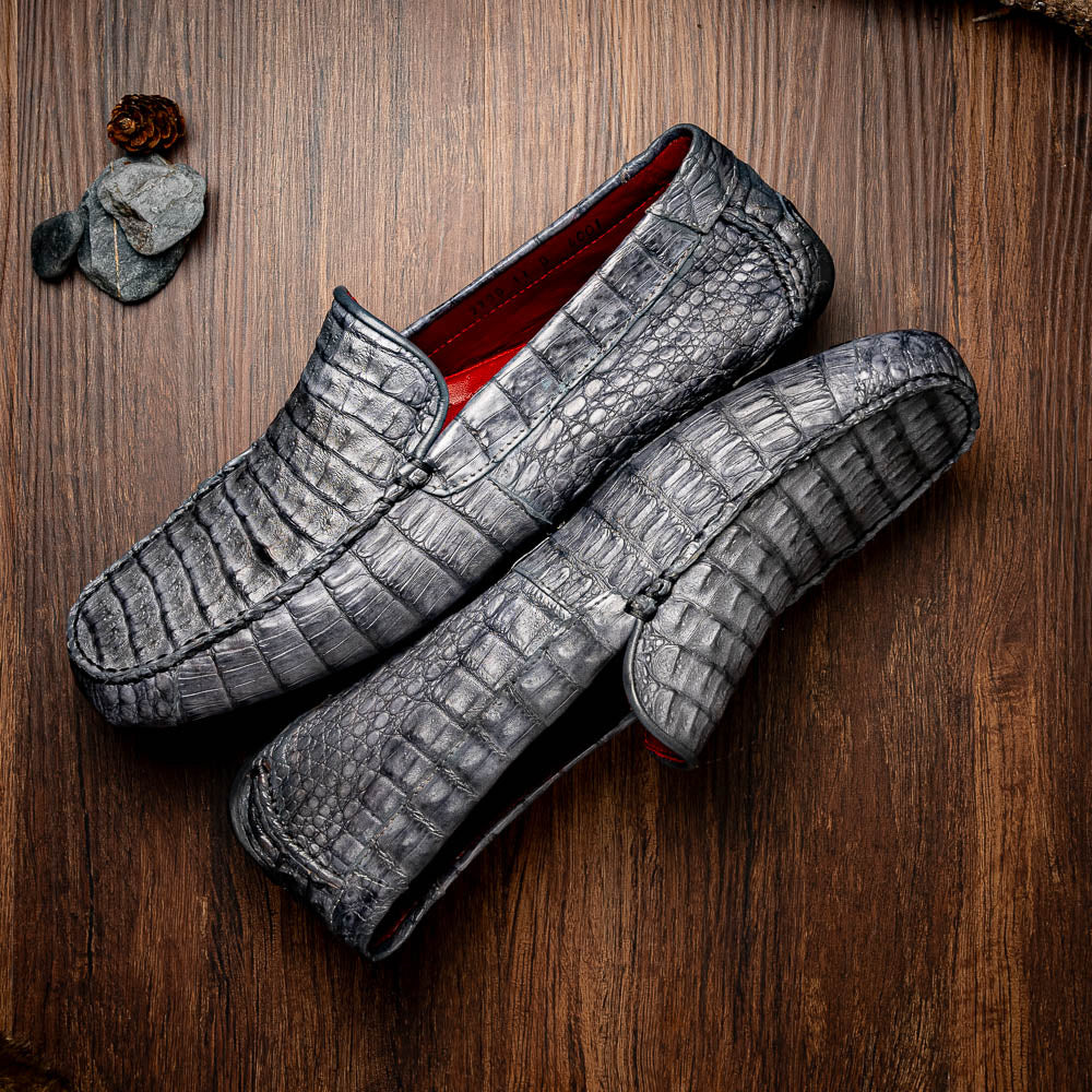 The Remo Gray driving loafers by Marco Di Milano feature a textured gray upper and rubber sole, with one shoe upright and the other leaning—ideal for genuine exotic footwear enthusiasts.