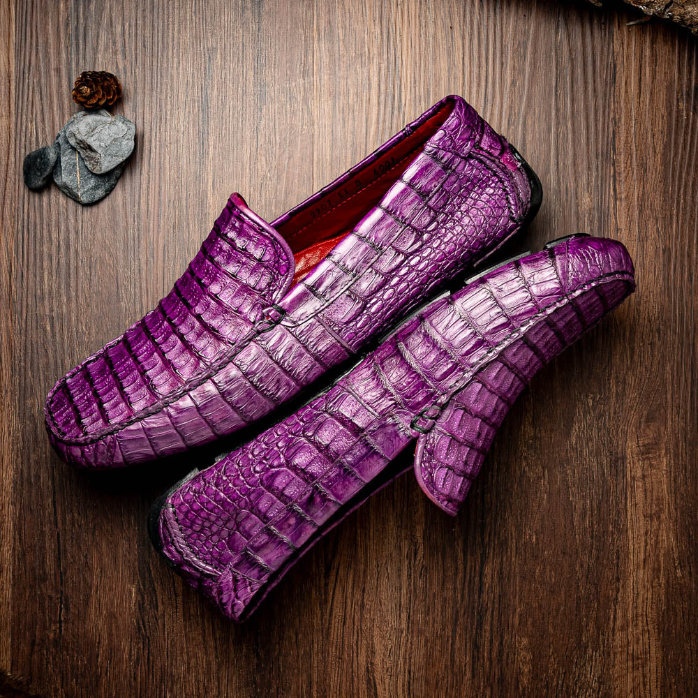 The Remo Purple by Marco Di Milano: a pair of crocodile-patterned purple leather driving loafers, one upright and one on its side revealing the black rubber sole—luxury men's footwear at its finest.