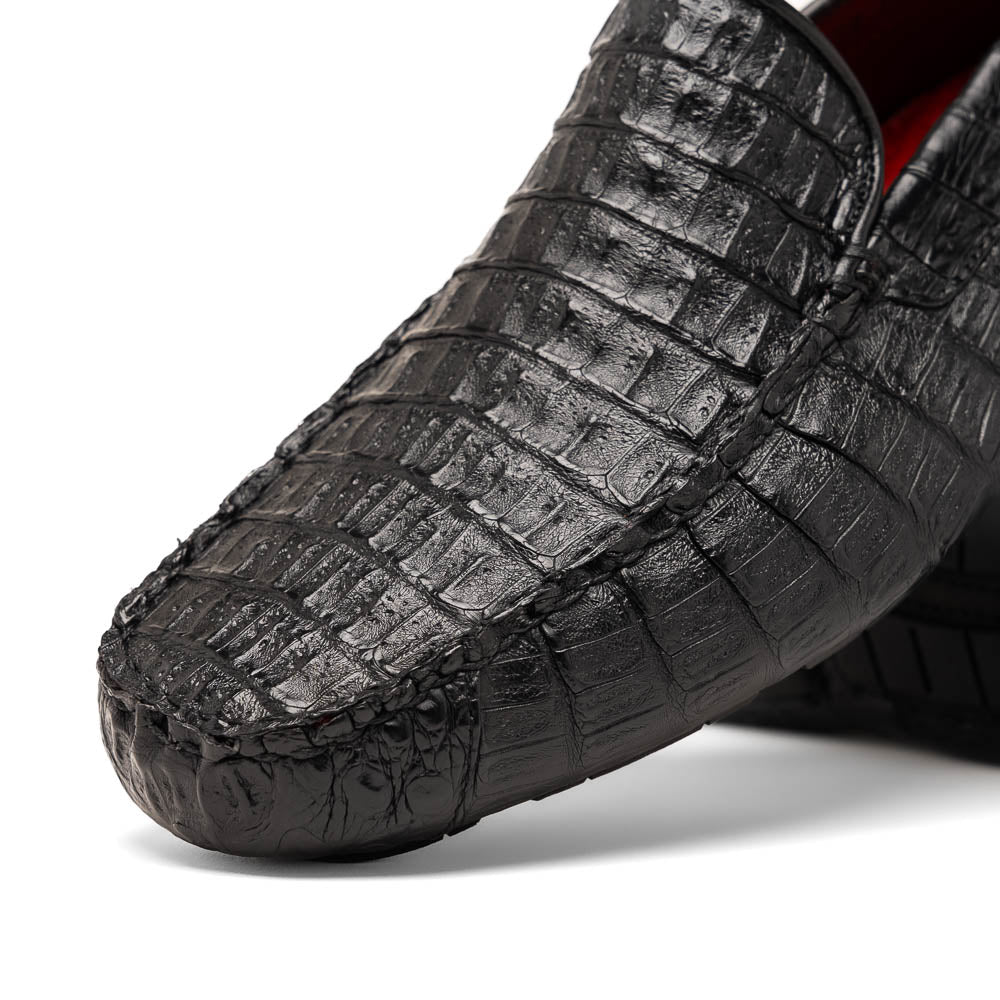 The Remo Black by Marco Di Milano: a pair of black textured driving loafers with a crocodile pattern—one upright, one showing the sole—making a bold statement in luxury men's footwear.