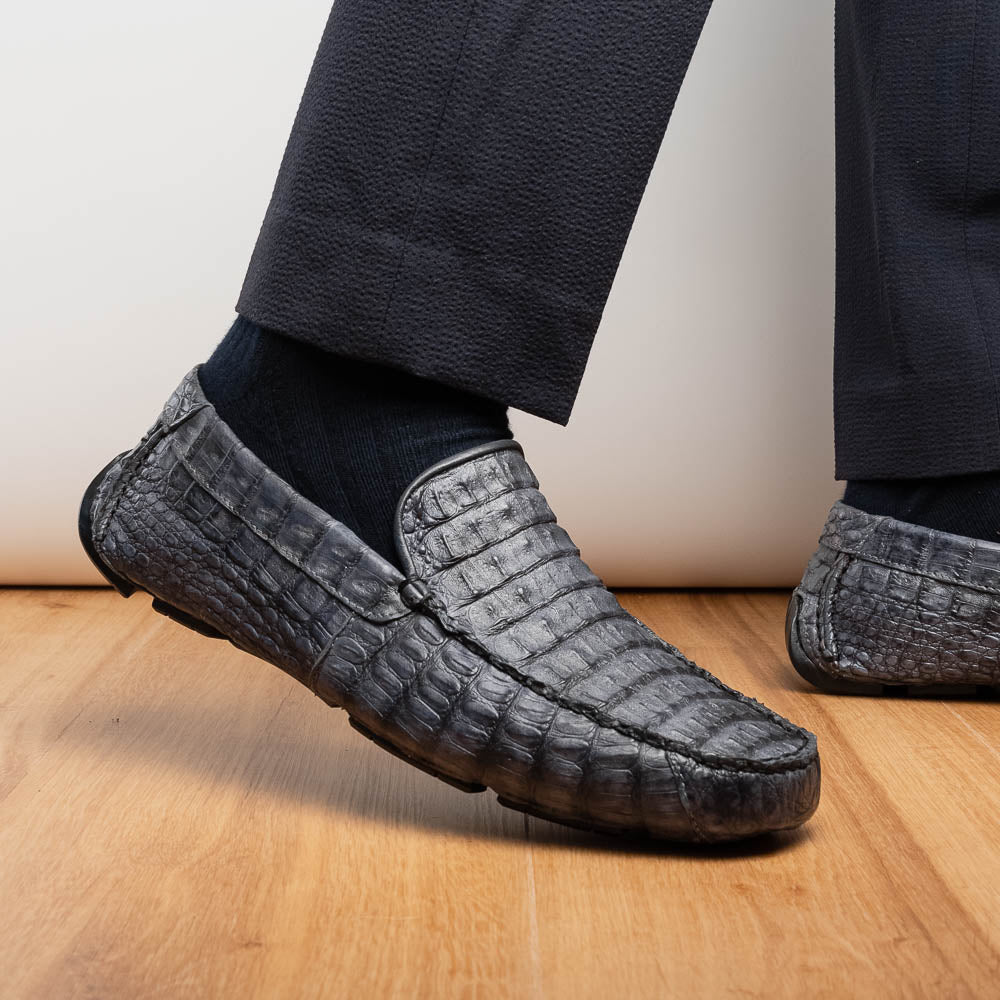 The Remo Gray driving loafers by Marco Di Milano feature a textured gray upper and rubber sole, with one shoe upright and the other leaning—ideal for genuine exotic footwear enthusiasts.