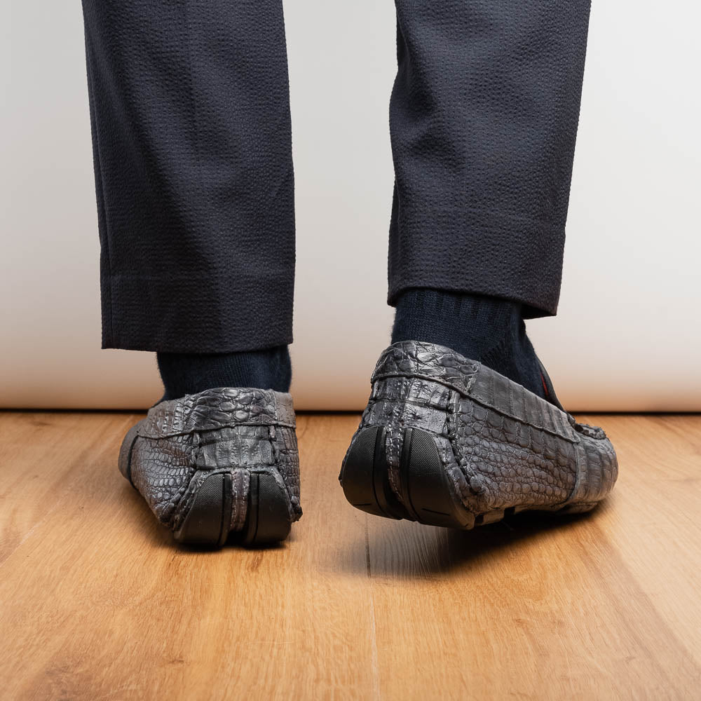 The Remo Gray driving loafers by Marco Di Milano feature a textured gray upper and rubber sole, with one shoe upright and the other leaning—ideal for genuine exotic footwear enthusiasts.