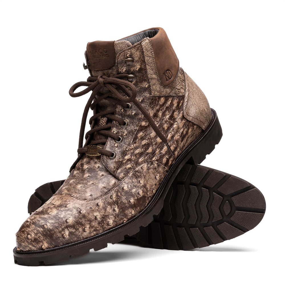 The Renzo Stone Brown by Marco Di Milano are lace-up ankle boots featuring a textured, speckled pattern and thick black rubber soles—one stands upright while the other lies on its side—ideal for luxury footwear lovers.