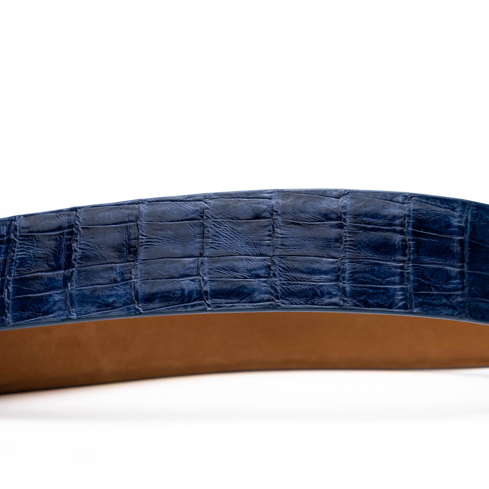 The Riccardo Belt Blue Jeans by Marco Di Milano, crafted from genuine caiman fuscus-belly leather with a crocodile-embossed finish and a silver engraved buckle, is showcased coiled on white—a bold pick for exotic belt enthusiasts.