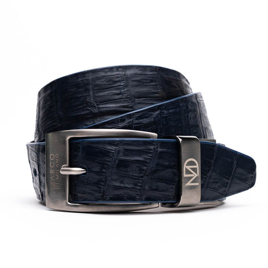 The Riccardo Belt Navy by Marco Di Milano features genuine exotic leather with a crocodile pattern, a dark blue finish, and a silver buckle with engraved branding and initials.
