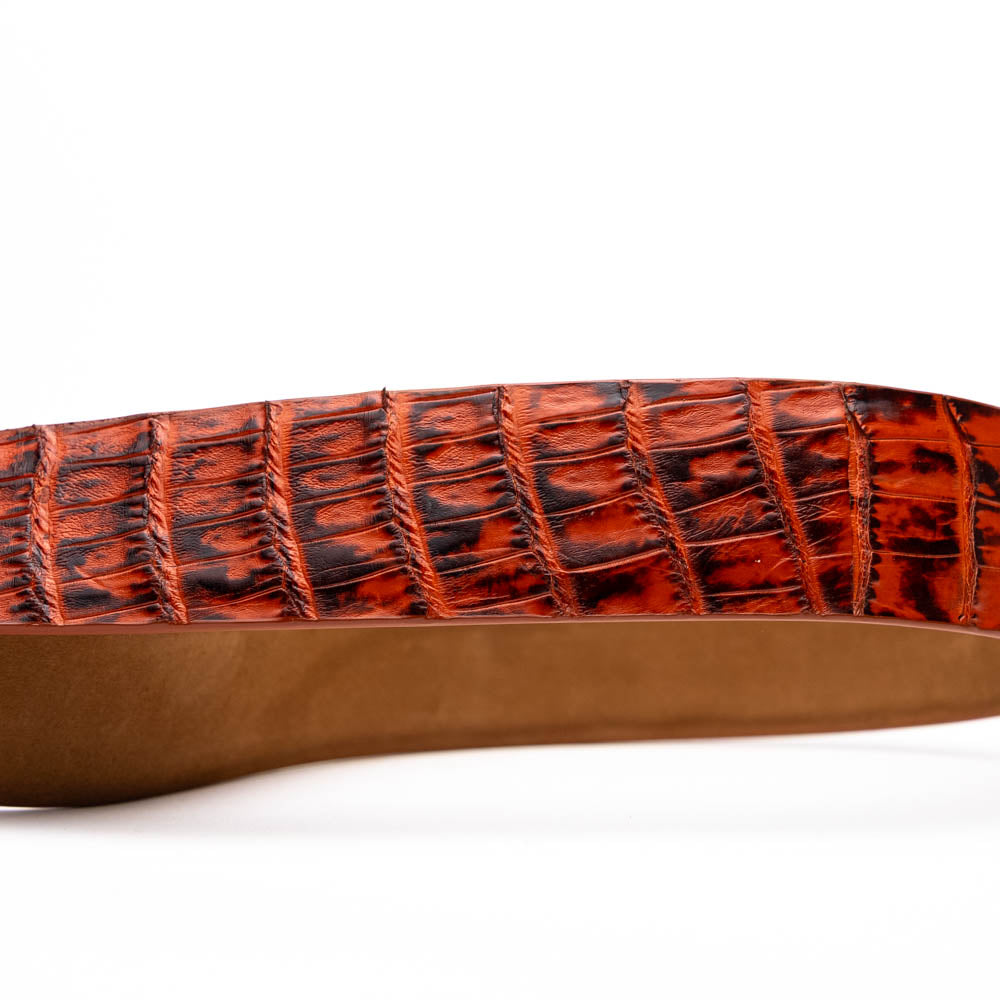 The Riccardo Belt Rustic Cognac by Marco Di Milano features a crocodile-patterned brown caiman fuscus-belly, a silver buckle, and genuine exotic leather—an ideal complement to luxury footwear.