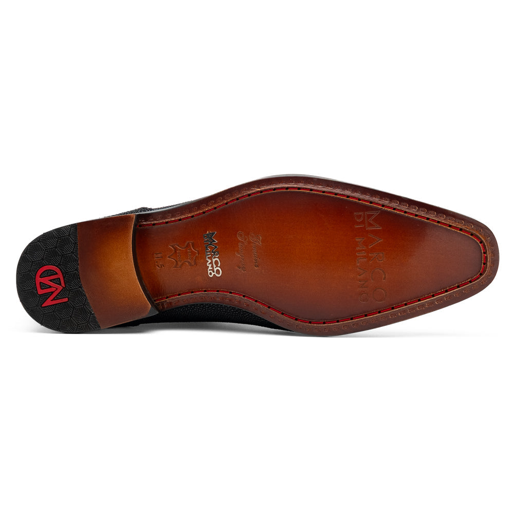 A pair of Rimini Black luxury dress shoes by Marco Di Milano, featuring a black textured finish and lace-up closure—one shoe displayed upright while the other shows the brown leather sole with embossed branding.