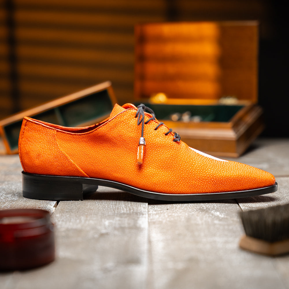 Rimini Orange men’s exotic lace-up dress shoes by Marco Di Milano, expertly crafted from genuine stingray leather in a bright orange hue with black laces; one shoe stands upright while the other lies on its side, showcasing the vibrant red sole and contrasting black heel.