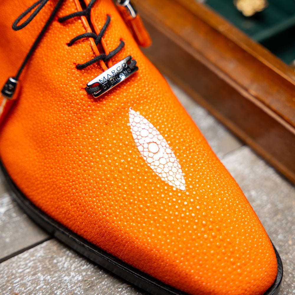 Rimini Orange men’s exotic lace-up dress shoes by Marco Di Milano, expertly crafted from genuine stingray leather in a bright orange hue with black laces; one shoe stands upright while the other lies on its side, showcasing the vibrant red sole and contrasting black heel.