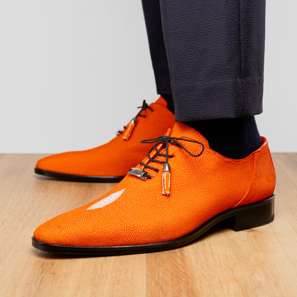 Rimini Orange men’s exotic lace-up dress shoes by Marco Di Milano, expertly crafted from genuine stingray leather in a bright orange hue with black laces; one shoe stands upright while the other lies on its side, showcasing the vibrant red sole and contrasting black heel.