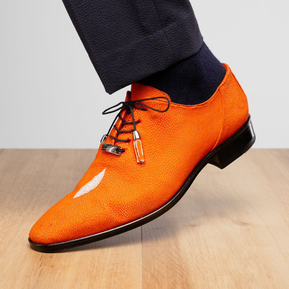 Rimini Orange men’s exotic lace-up dress shoes by Marco Di Milano, expertly crafted from genuine stingray leather in a bright orange hue with black laces; one shoe stands upright while the other lies on its side, showcasing the vibrant red sole and contrasting black heel.