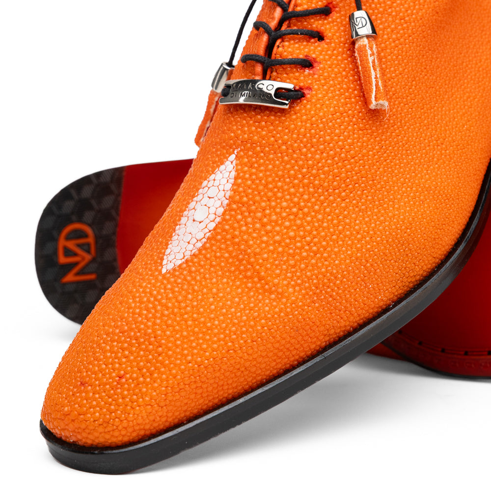 Rimini Orange men’s exotic lace-up dress shoes by Marco Di Milano, expertly crafted from genuine stingray leather in a bright orange hue with black laces; one shoe stands upright while the other lies on its side, showcasing the vibrant red sole and contrasting black heel.