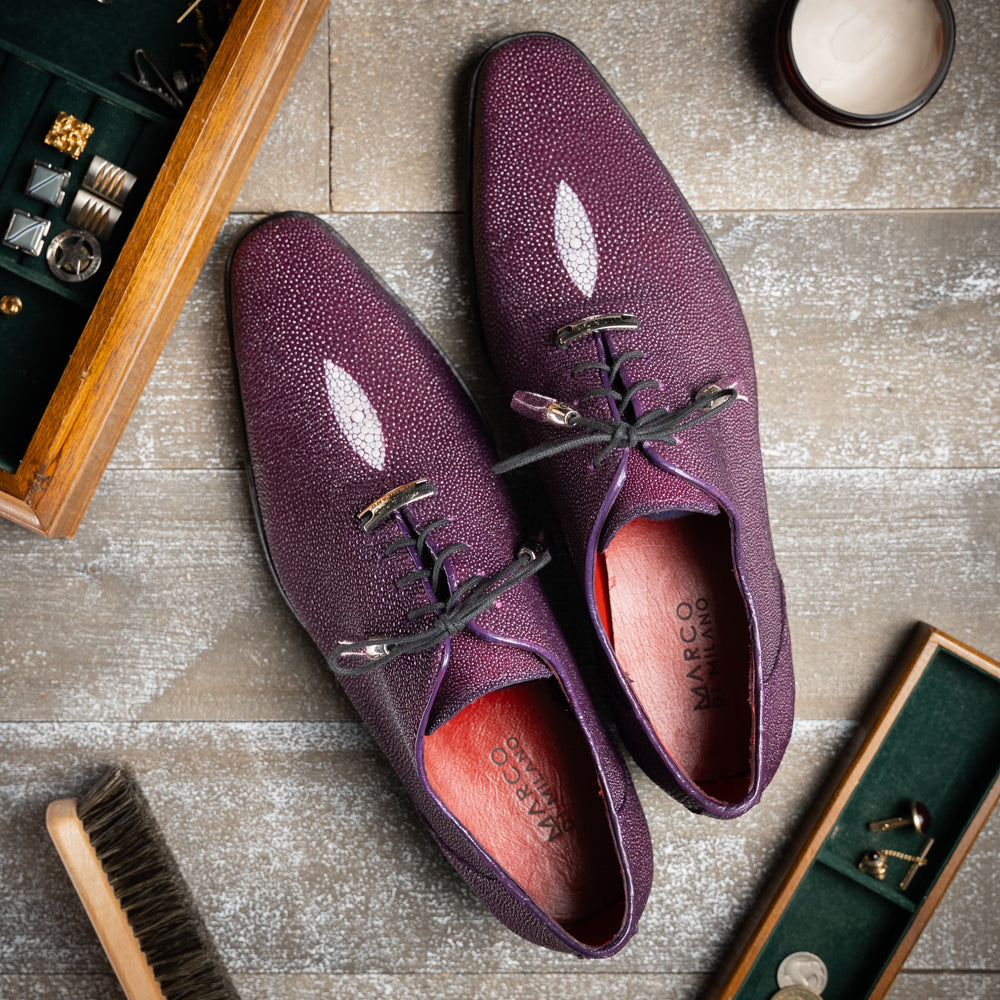 The Rimini Purple by Marco Di Milano is a single purple textured exotic lace-up shoe with black laces, shown from above, featuring a decorative metal and crystal accessory on the tongue.