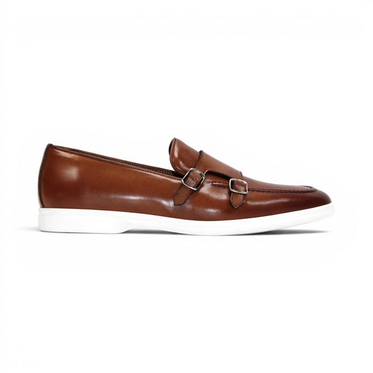 The Duca Di Matiste Duca Rimini Cognac is a brown premium calf leather loafer with metal buckle details and a white rubber sole, showcasing timeless sophistication in its side profile against a plain white background.