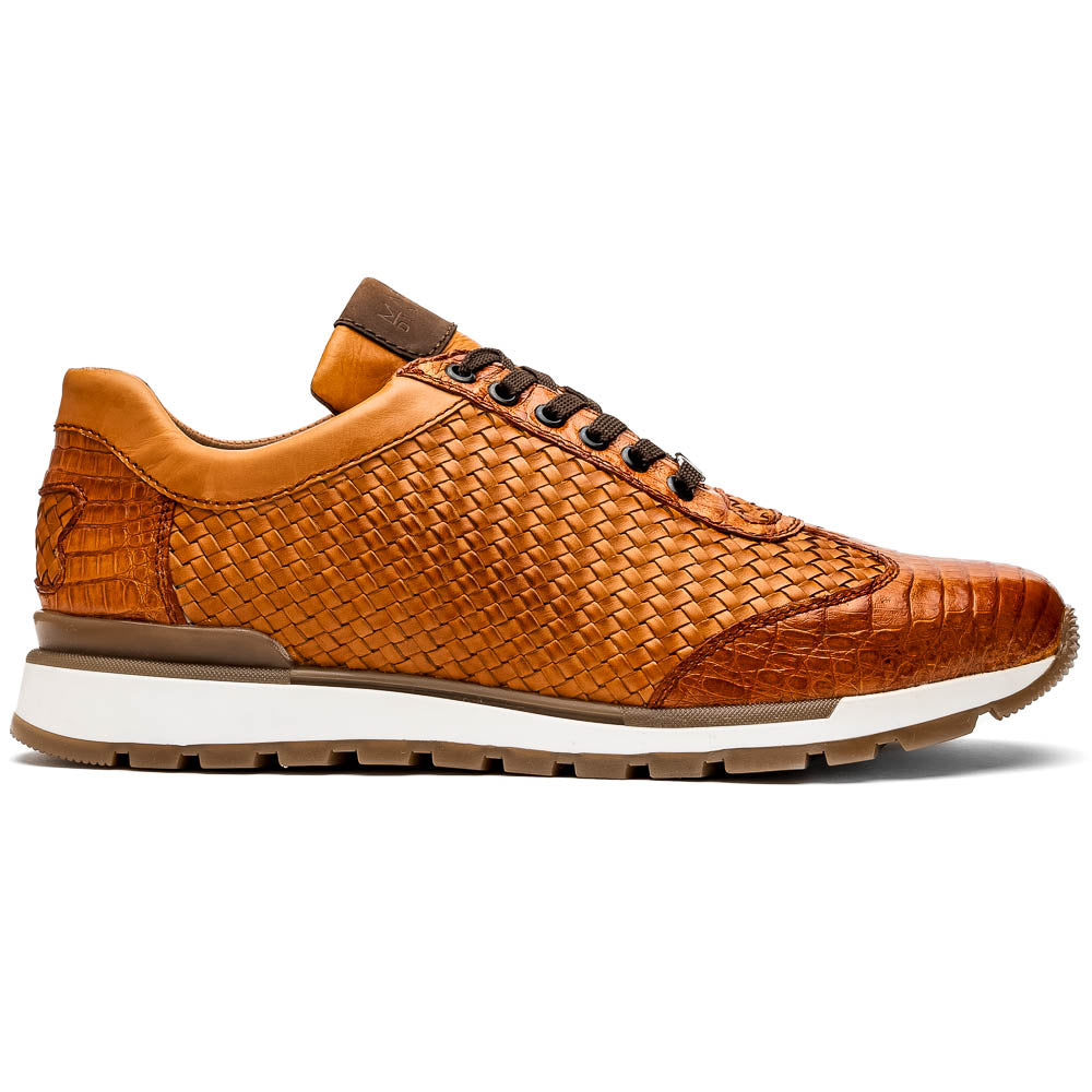 The Roma Brandy sneakers by Marco Di Milano feature brown woven calfskin, textured toe and heel, black laces, white midsoles, and brown rubber outsoles. One shoe stands upright while the other lies on its side.