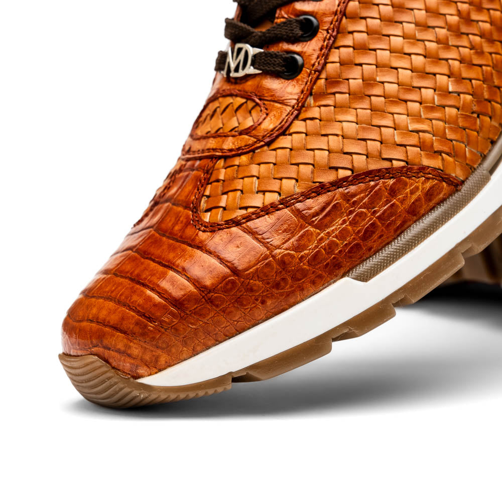 The Roma Brandy sneakers by Marco Di Milano feature brown woven calfskin, textured toe and heel, black laces, white midsoles, and brown rubber outsoles. One shoe stands upright while the other lies on its side.