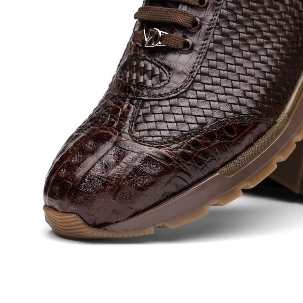 The Marco Di Milano Roma Brown sneakers feature hand-painted textured leather, woven detailing, and rubber soles. One luxury pair stands upright while the other is tilted beneath it.