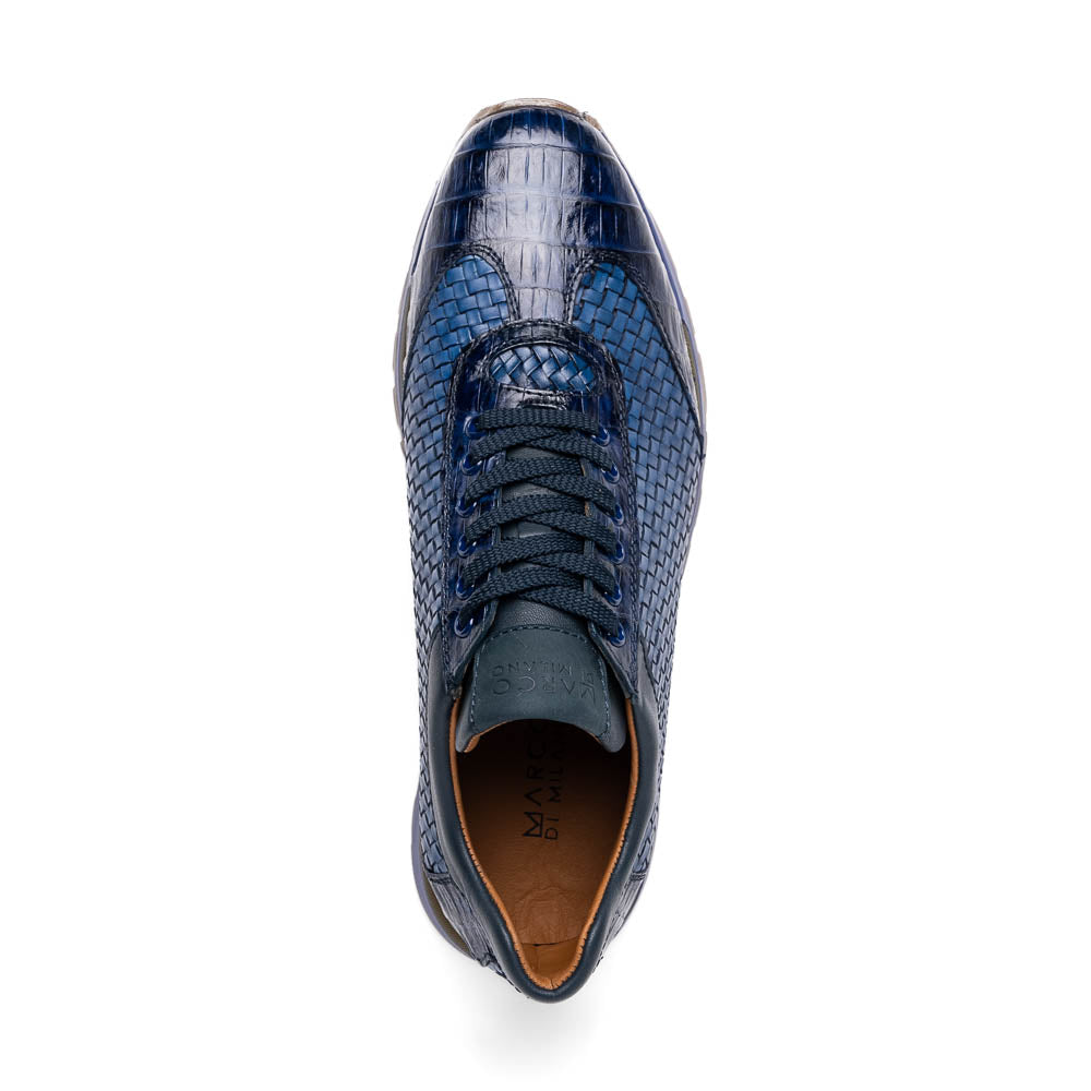 A pair of Marco Di Milano's Roma Navy sneakers: blue woven calfskin with brown rubber soles, one upright and the other leaning, highlighting the distinct tread pattern in elegant style.