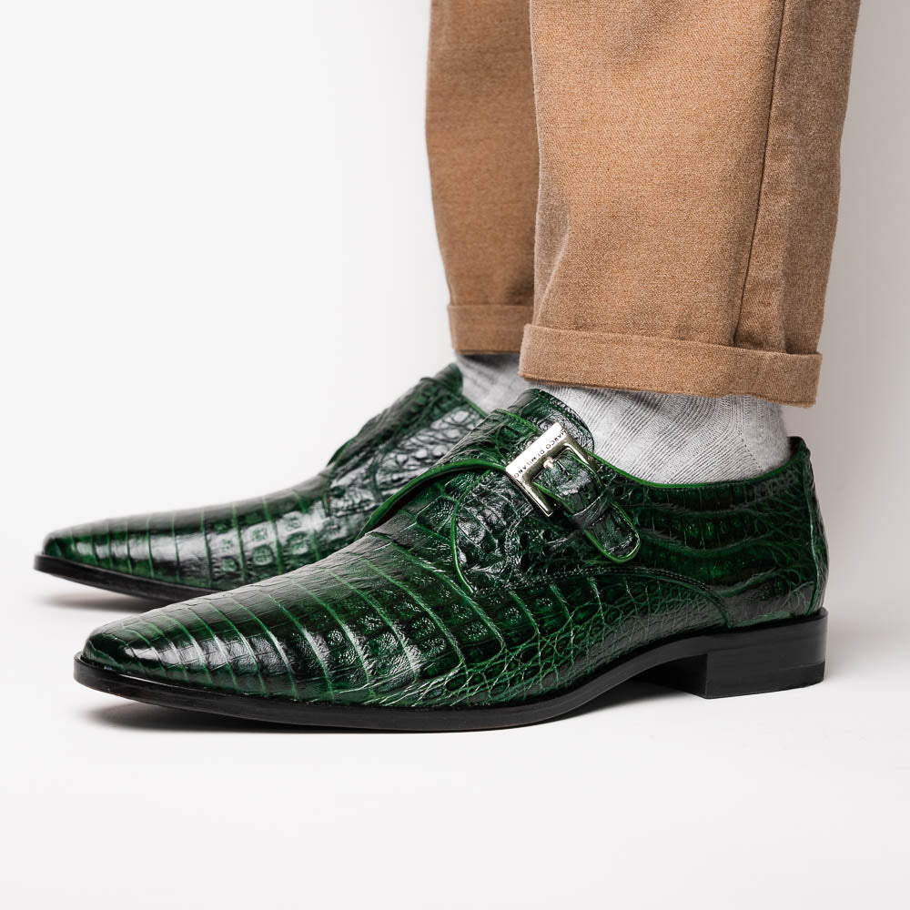 The Marco Di Milano Rovigo Forest Green features genuine caiman crocodile leather and a luxury monk strap, with one dress shoe propped to reveal its sole—a bold statement among men's exotic dress shoes.